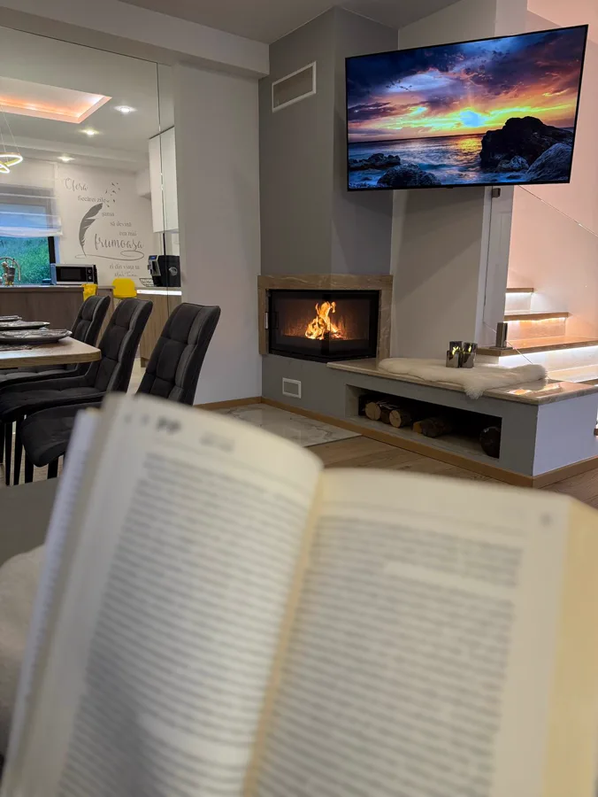 Relaxing moment with a book next to the lit fireplace